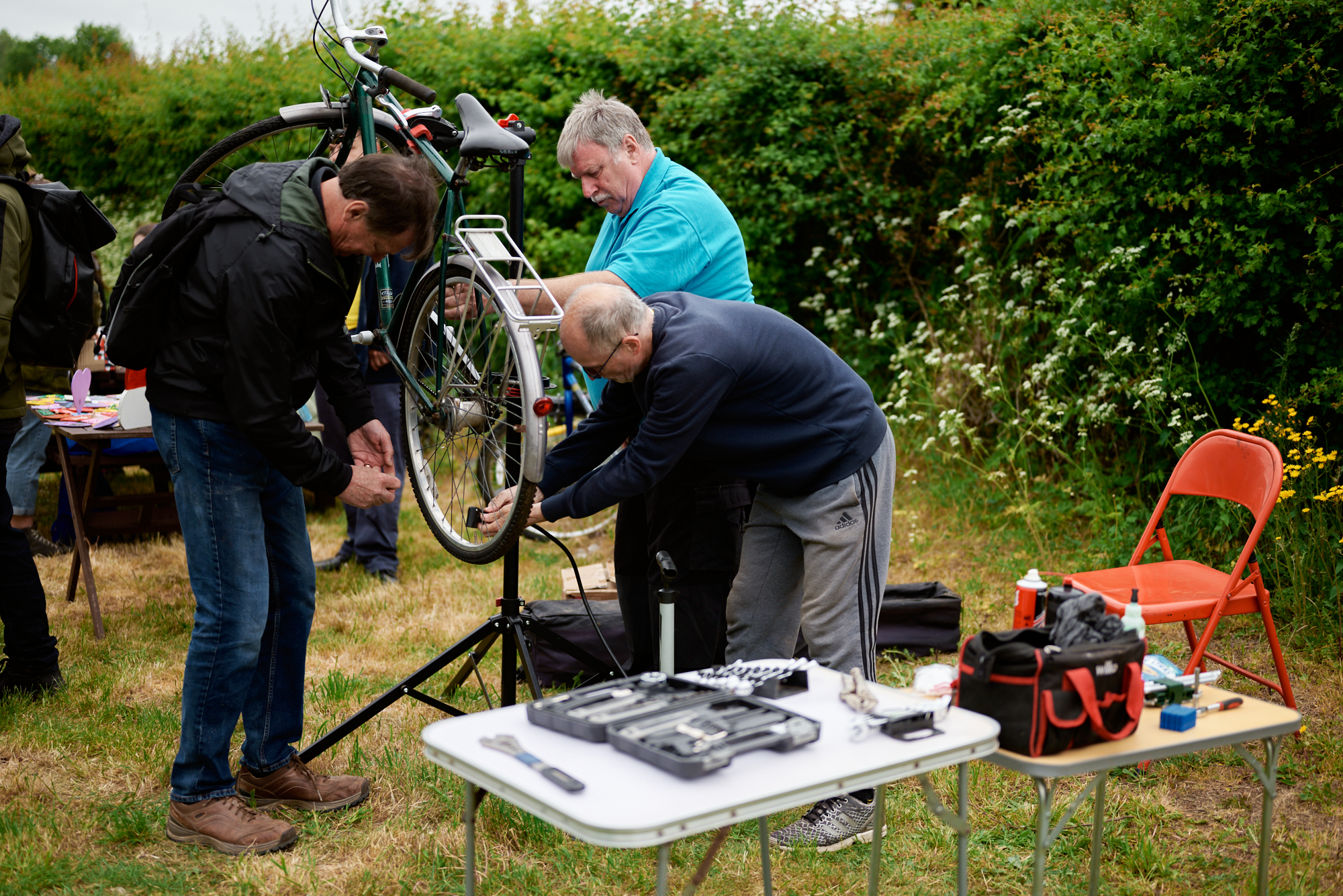 People repairing a bicycle outdoors as part of a practical skills activity